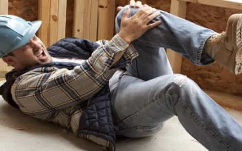 Construction worker clutching knee in pain